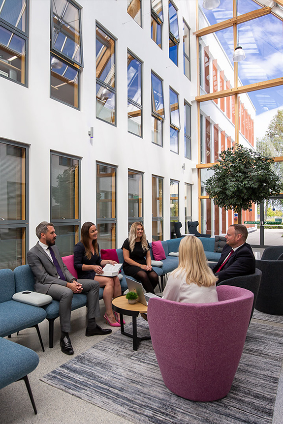 The Stonegate team meeting clients in the atrium of our modern offices.